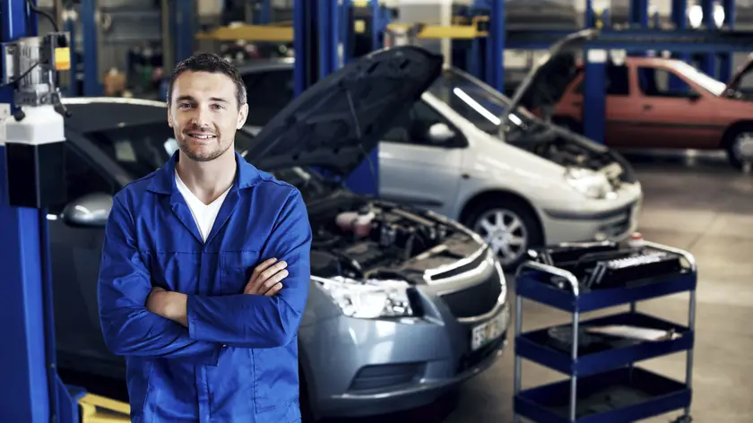 Servisní technik v autodílně v pracovním oděvu
